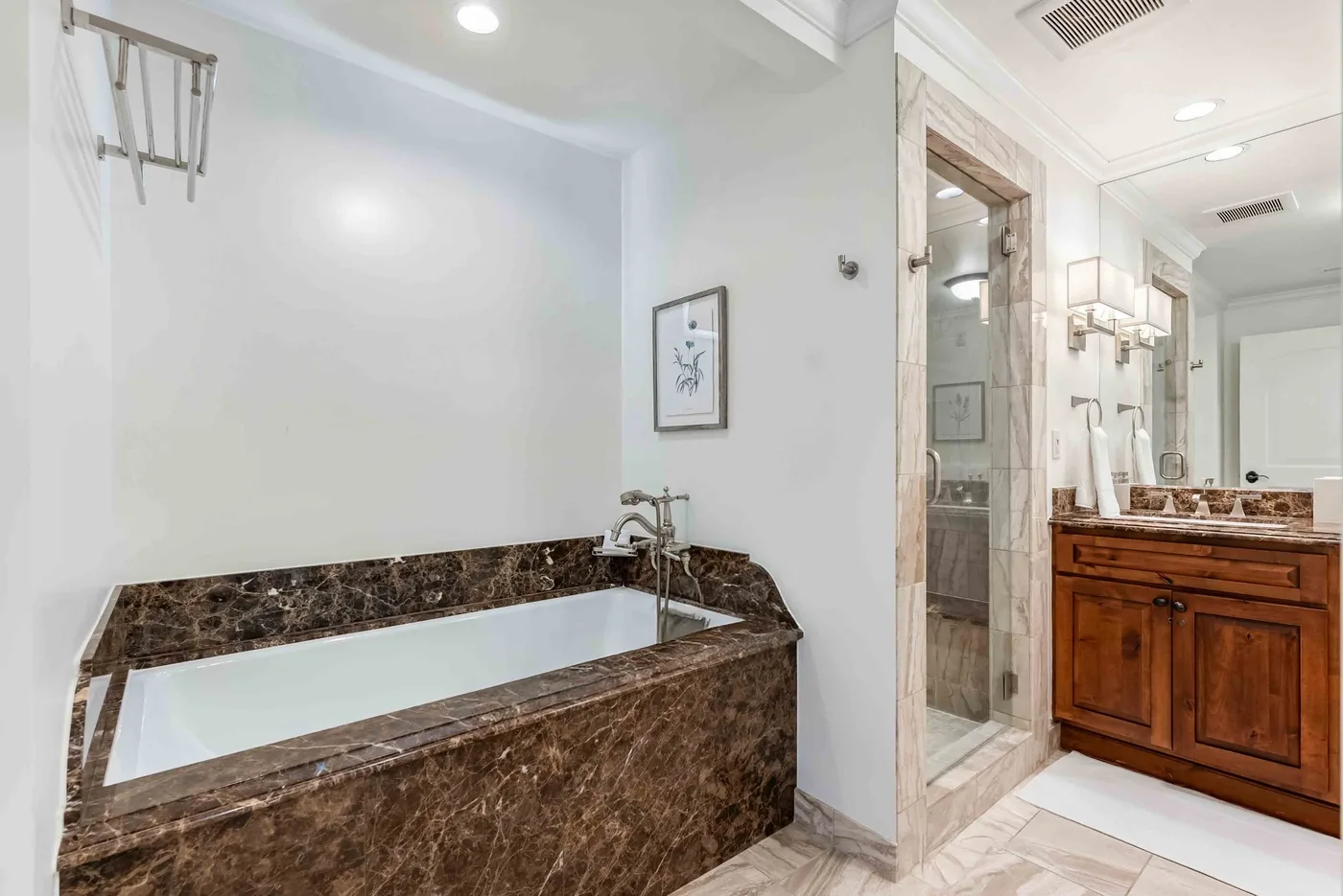 Un baño con una bañera empotrada y un tocador de madera junto a una ducha de vidrio.