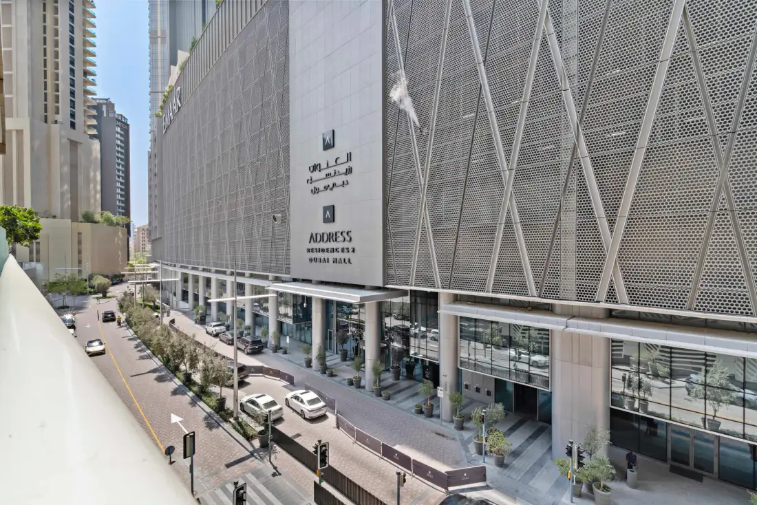 Un edificio urbano moderno con una fachada estampada junto a una calle.