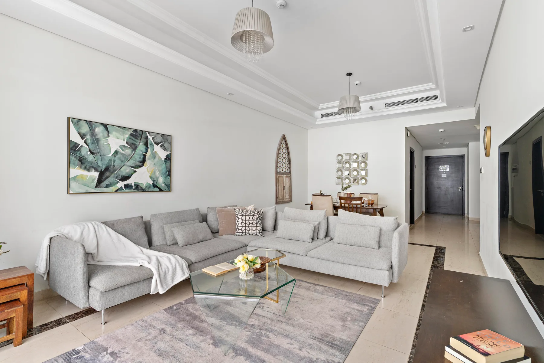 Una sala luminosa con asientos seccionales y una mesa de centro de vidrio.