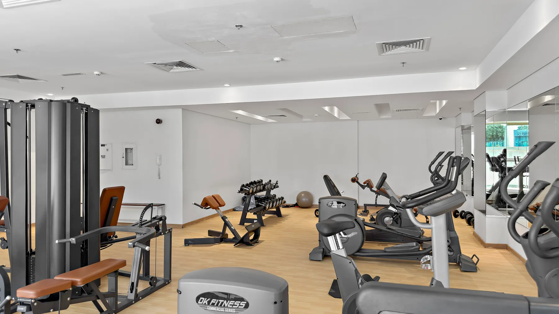Un gimnasio con máquinas de ejercicio y equipo de entrenamiento con pesas.