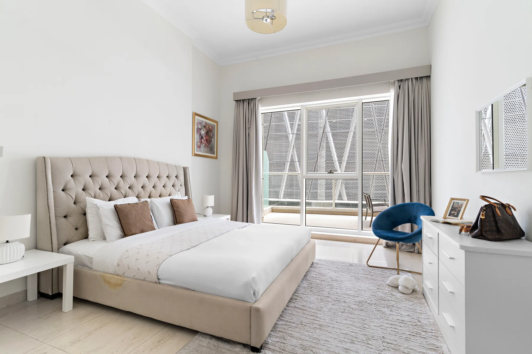 Un dormitorio luminoso con una cama grande y una puerta corrediza de vidrio.