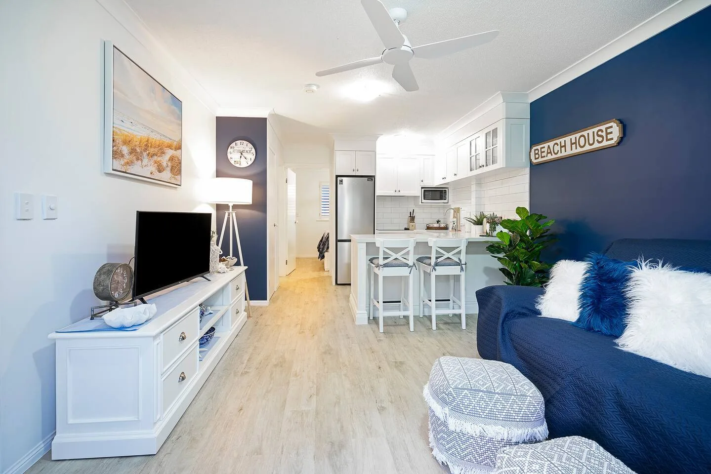 An open-plan living room and kitchen features a dining bar beside the seating area.