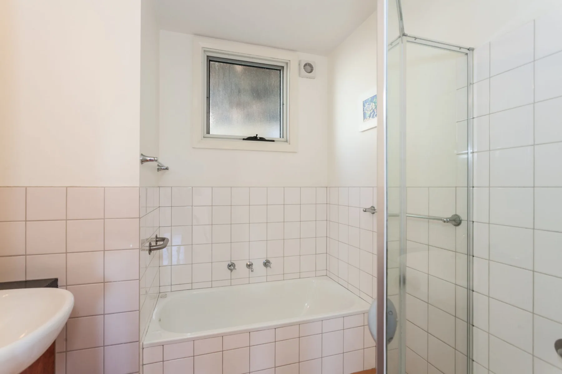 Baño alicatado con bañera y ducha independiente.