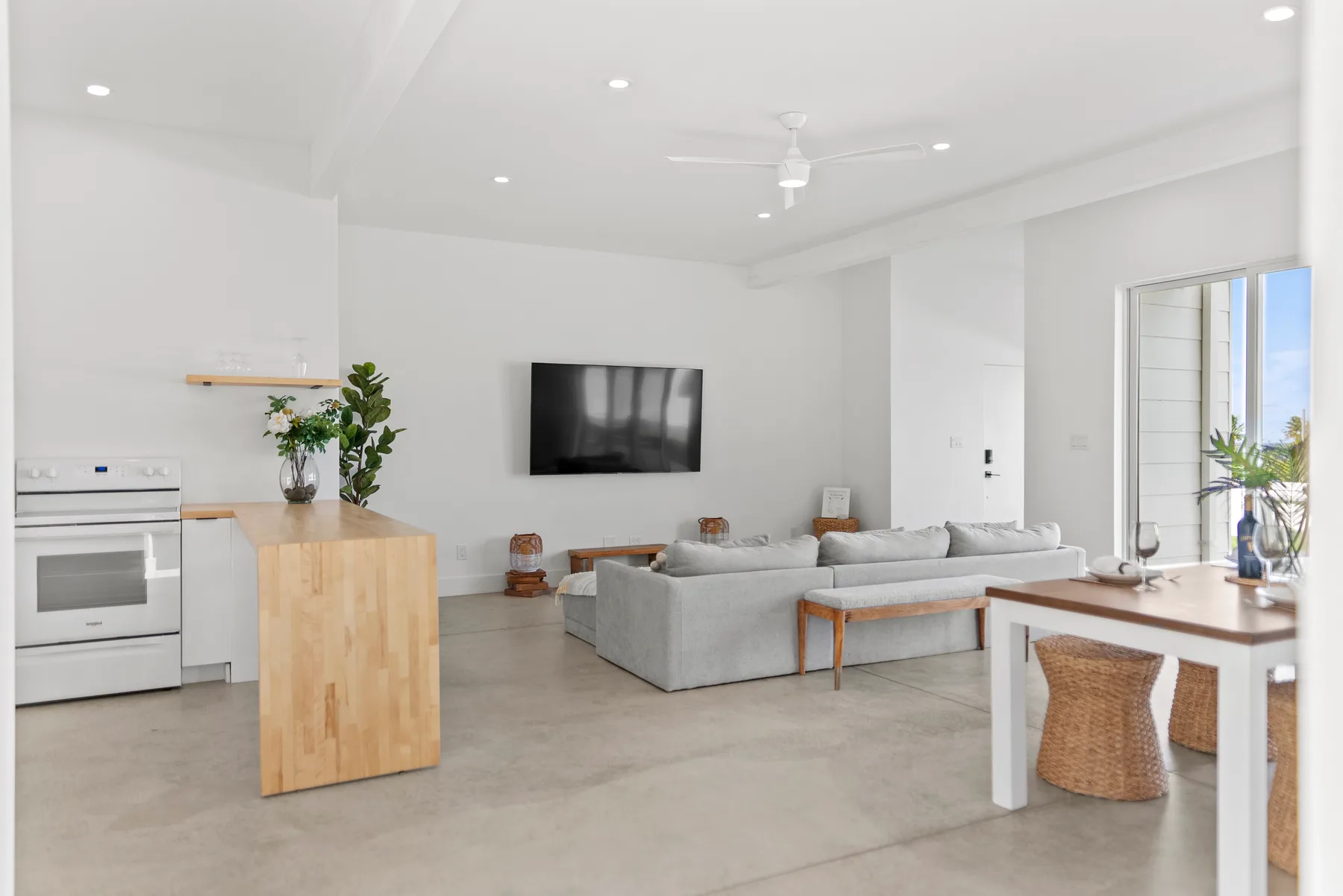 Open-plan living room with a television, seating, and a dining table.