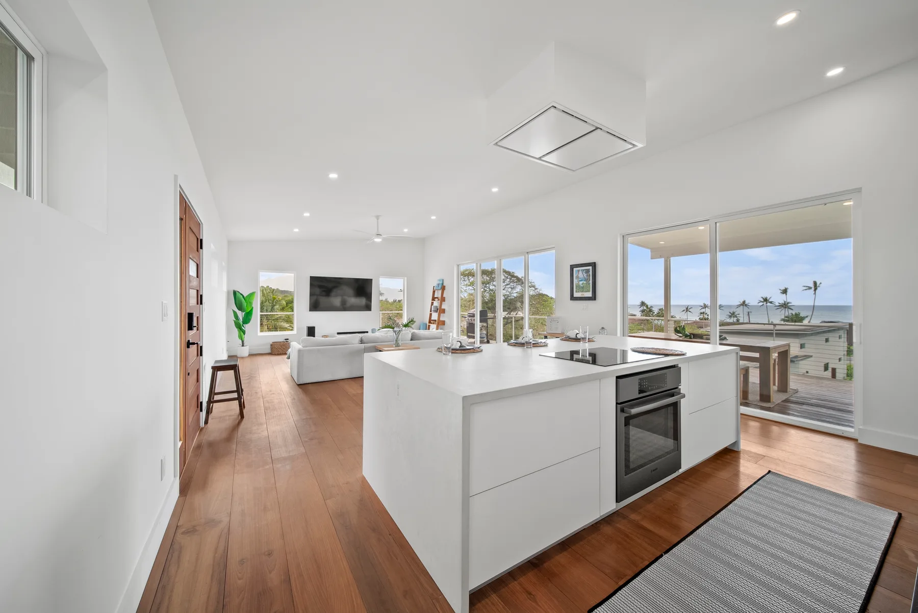 A bright open-plan kitchen and living area with large windows overlooking the water.