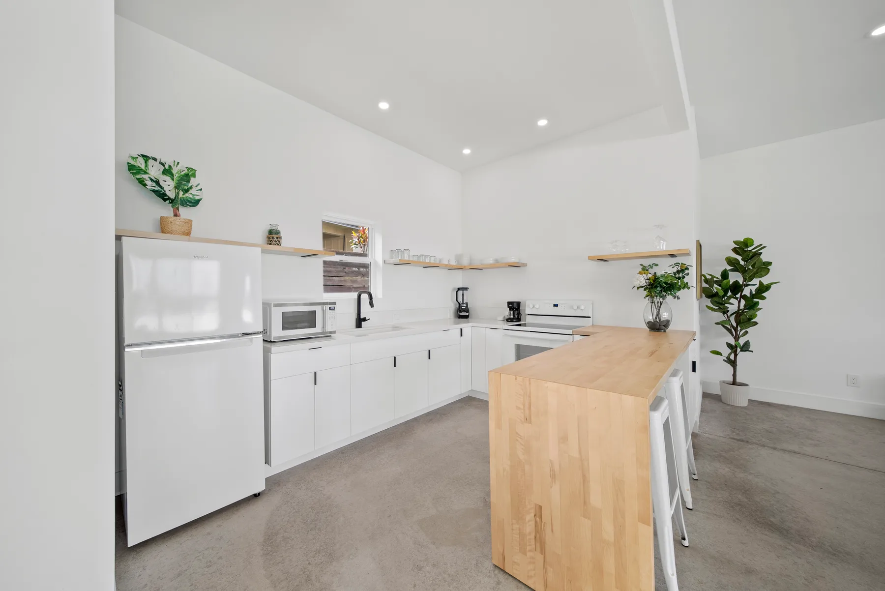 A bright kitchen with white cabinets and a wooden island.