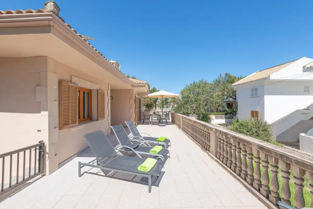 A sunny terrace with outdoor seating and a balustrade.
