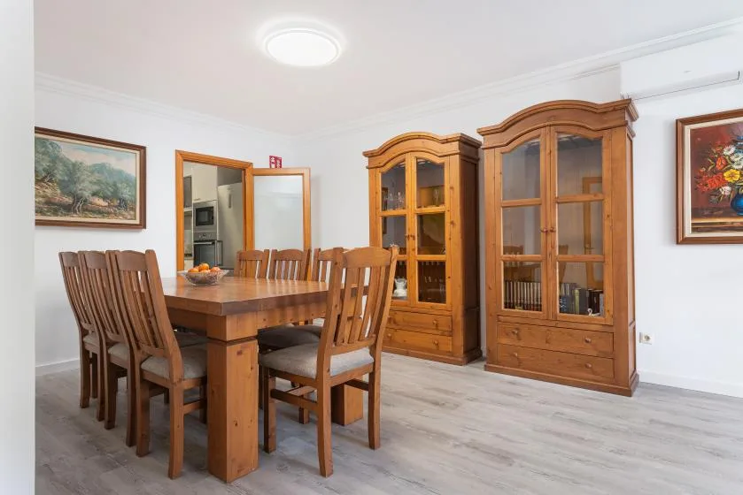 A dining room with a wooden table, seating, and glass-front cabinets.