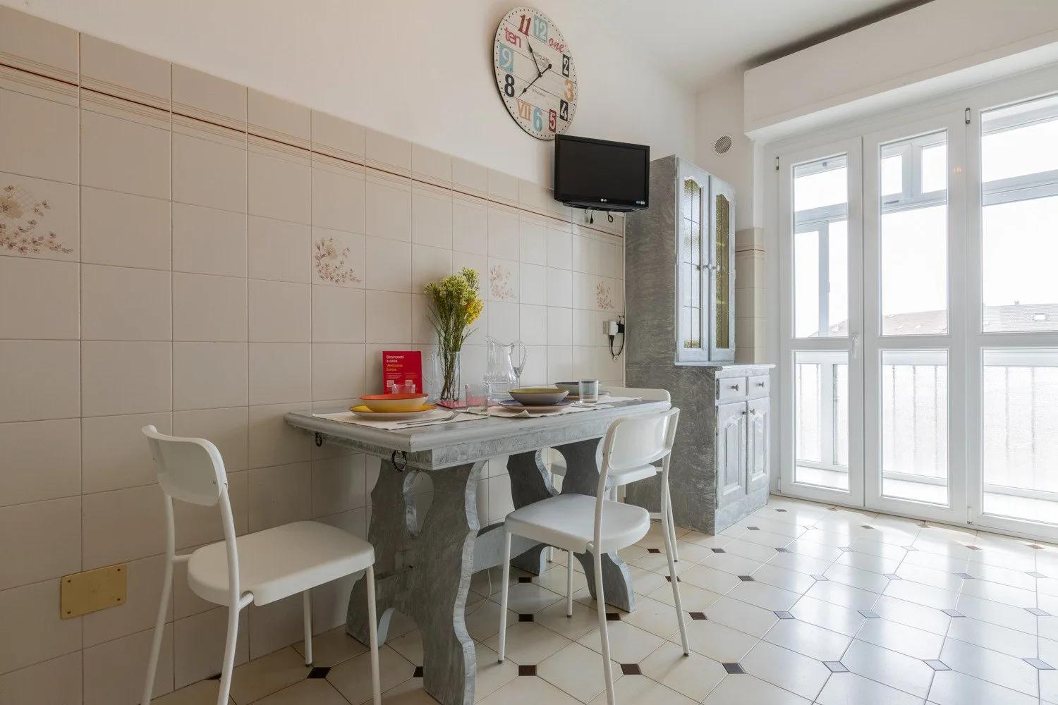 Un comedor luminoso con una mesa y sillas junto a grandes ventanas.