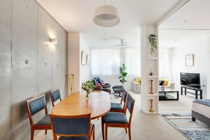 Una luminosa sala-comedor de planta abierta con una mesa de madera y asientos.