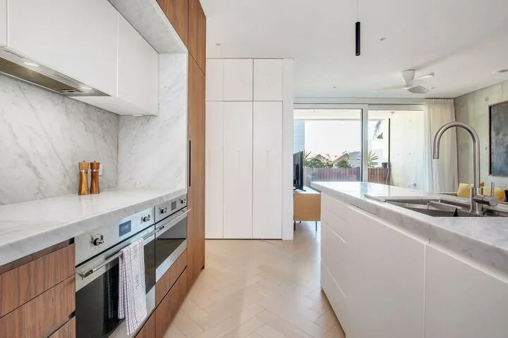 Una cocina moderna con una isla larga y puertas corredizas de vidrio.