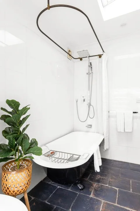 Un baño luminoso cuenta con una bañera exenta y una ducha superior.