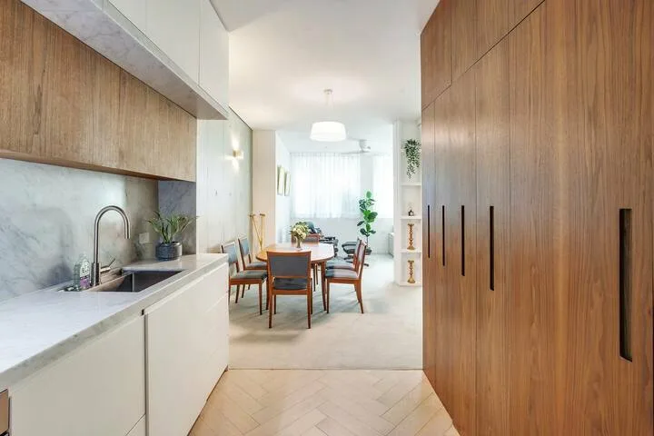 Una cocina abierta y zona de comedor con gabinetes de madera y una mesa.