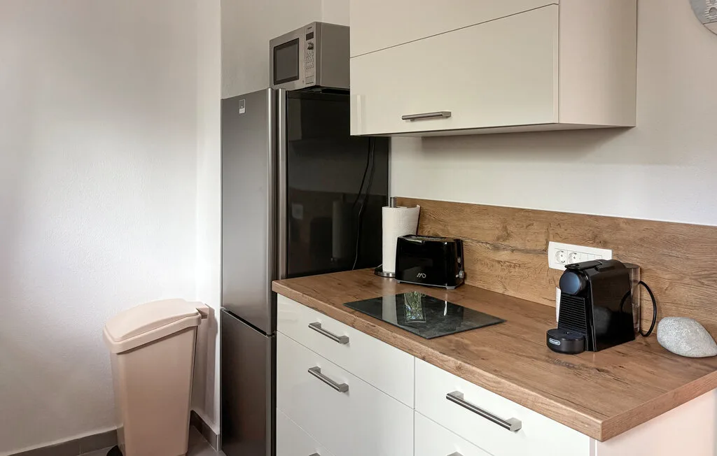 A compact kitchen with a refrigerator and countertop appliances.