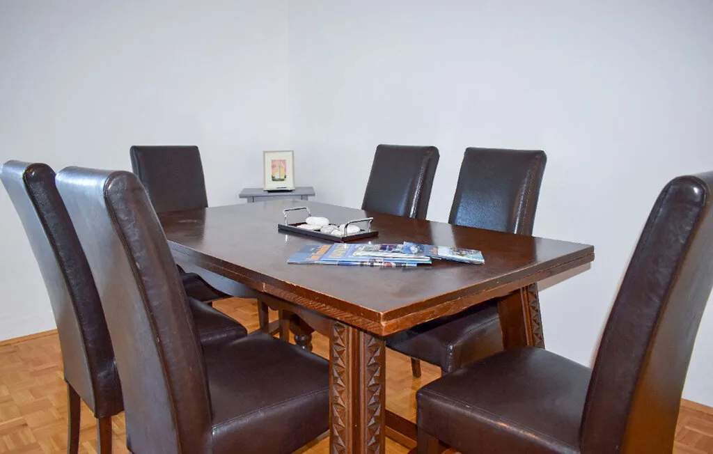 A dining room with a dark wooden table and upholstered seating.