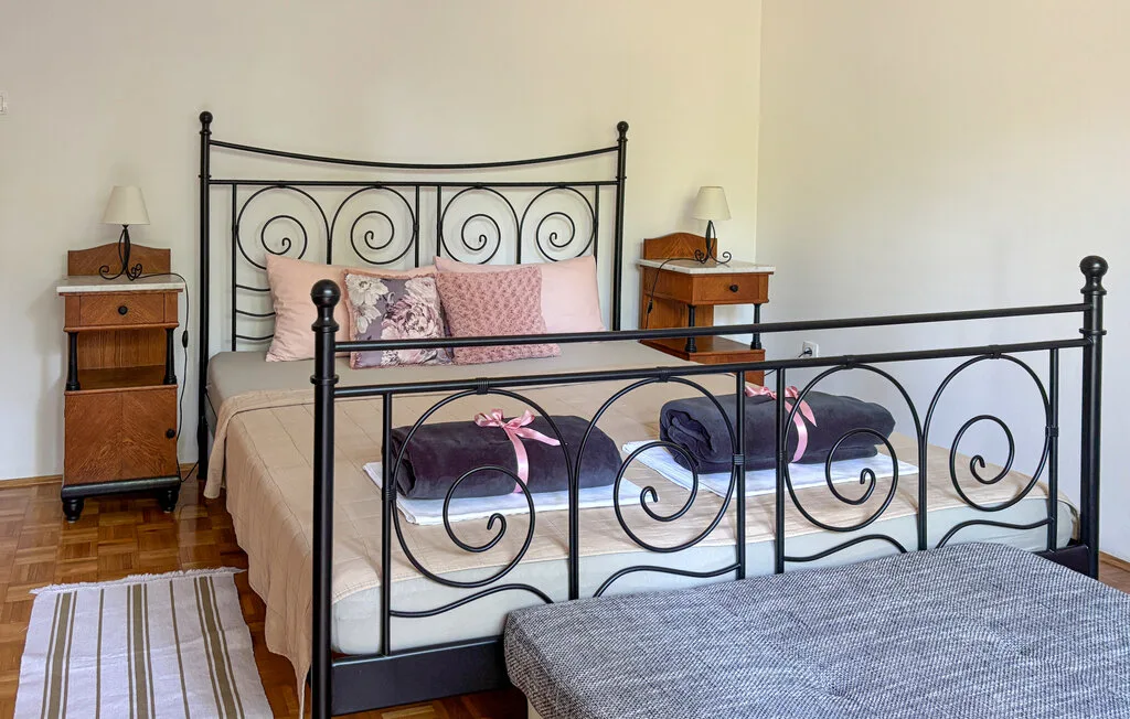 A bedroom with a metal bed and patterned pillows.