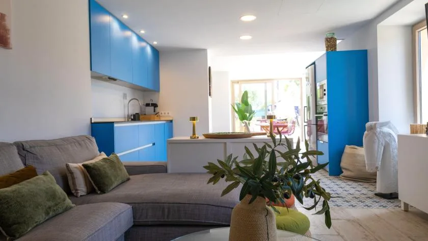 Una luminosa sala de estar de planta abierta con cocina y sofá seccional.