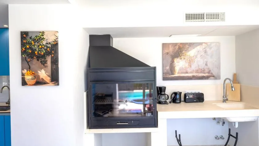 Una encimera de cocina con horno empotrado, pequeños electrodomésticos y fregadero.