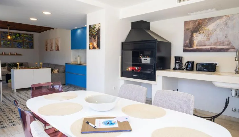 Una mesa de comedor y asientos están en una luminosa cocina abierta a la sala.