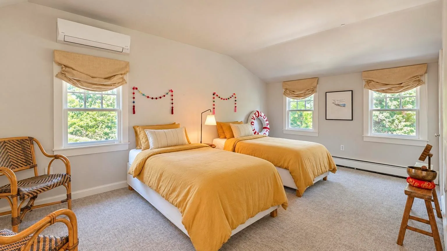 Un dormitorio con dos camas vestidas con ropa de cama amarilla y ventanas con persianas.