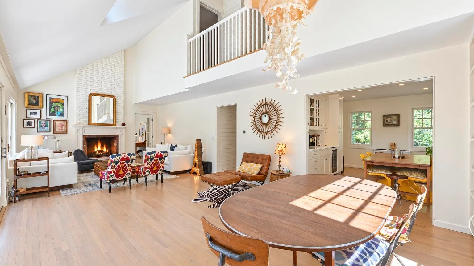 Una luminosa sala de estar y comedor de planta abierta, con chimenea y una gran mesa de madera.
