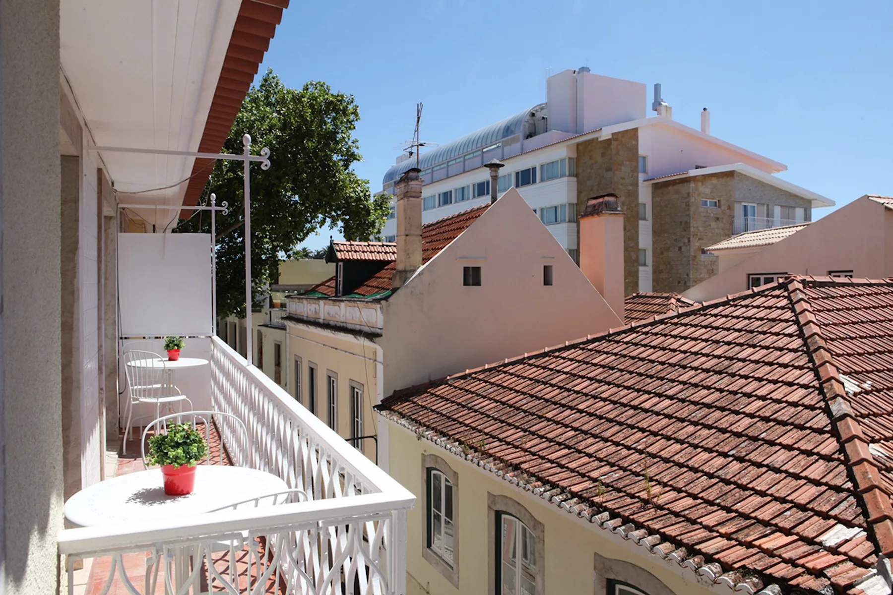 A balcony overlooks nearby buildings with terracotta-tiled roofs.