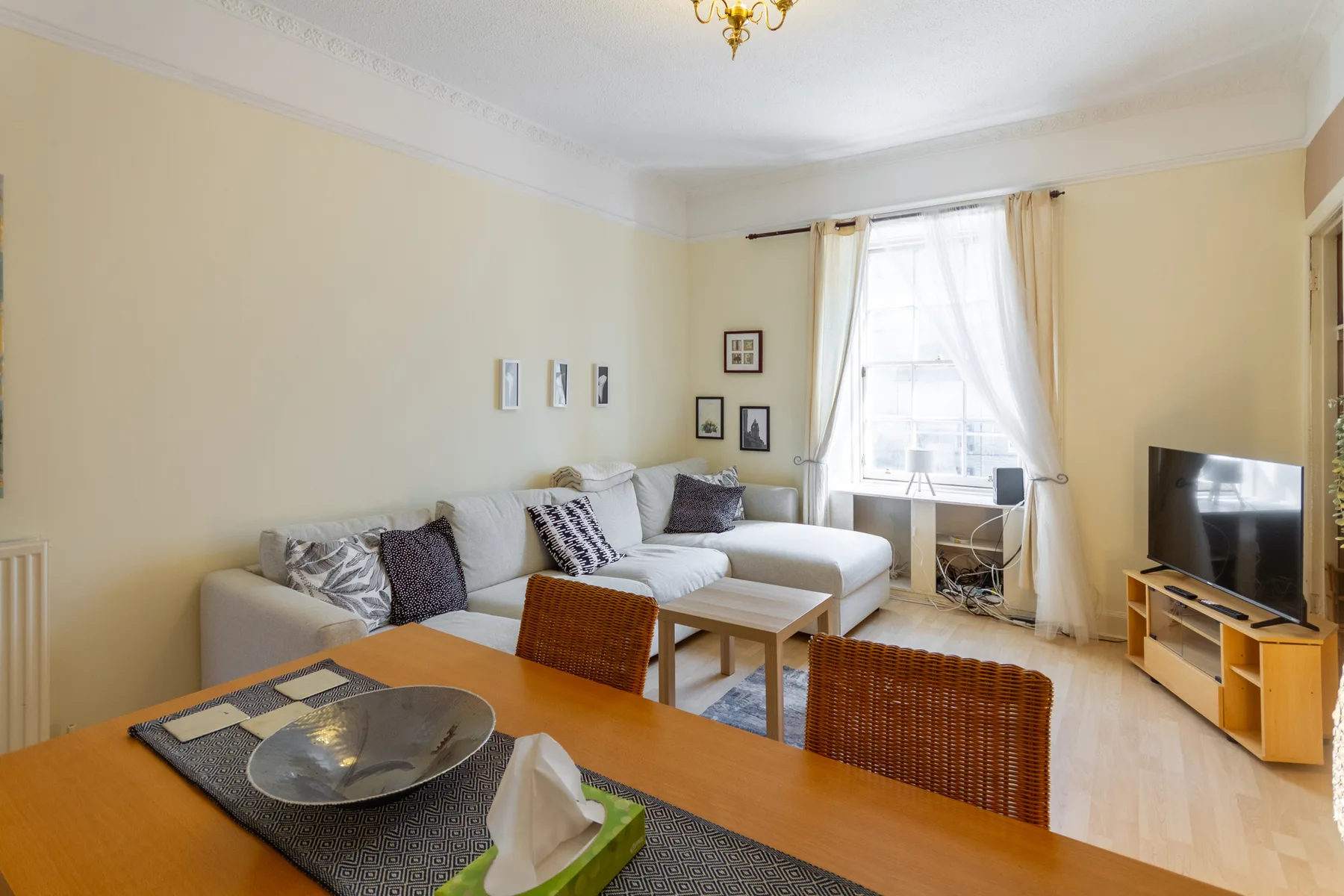 A living room with sectional seating, a coffee table, and a television.