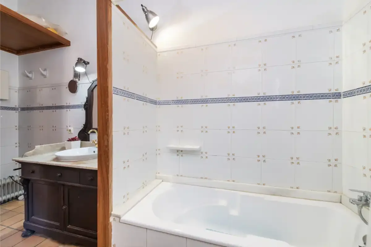 A tiled bathroom with a bathtub and sink.