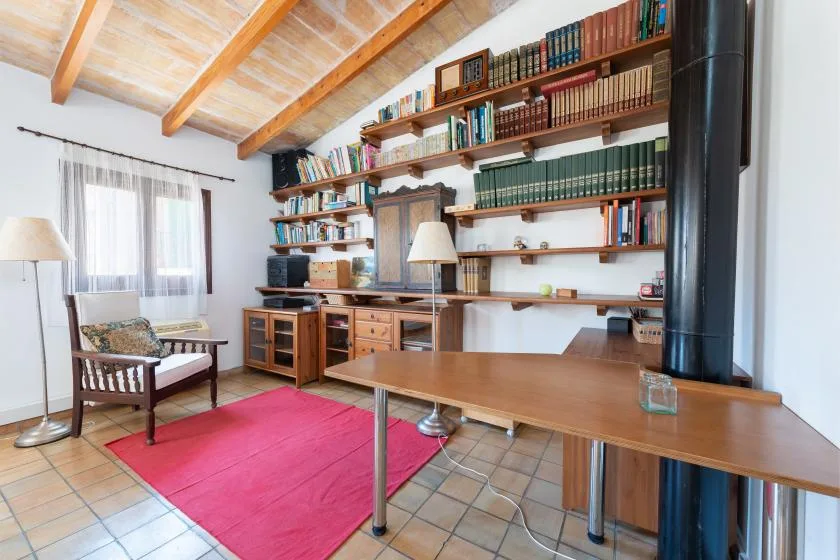 A study with bookshelves, a desk, and a bright pink rug.
