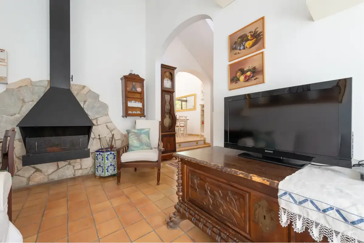 A living room with a fireplace, television, and wooden furniture.