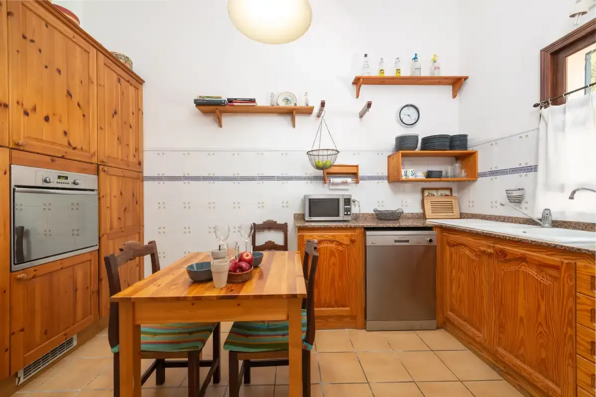 A kitchen with wooden cabinets and a dining table.