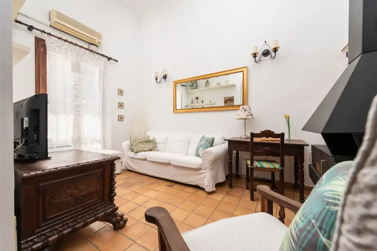 A living room with seating, a television, and a dining table.