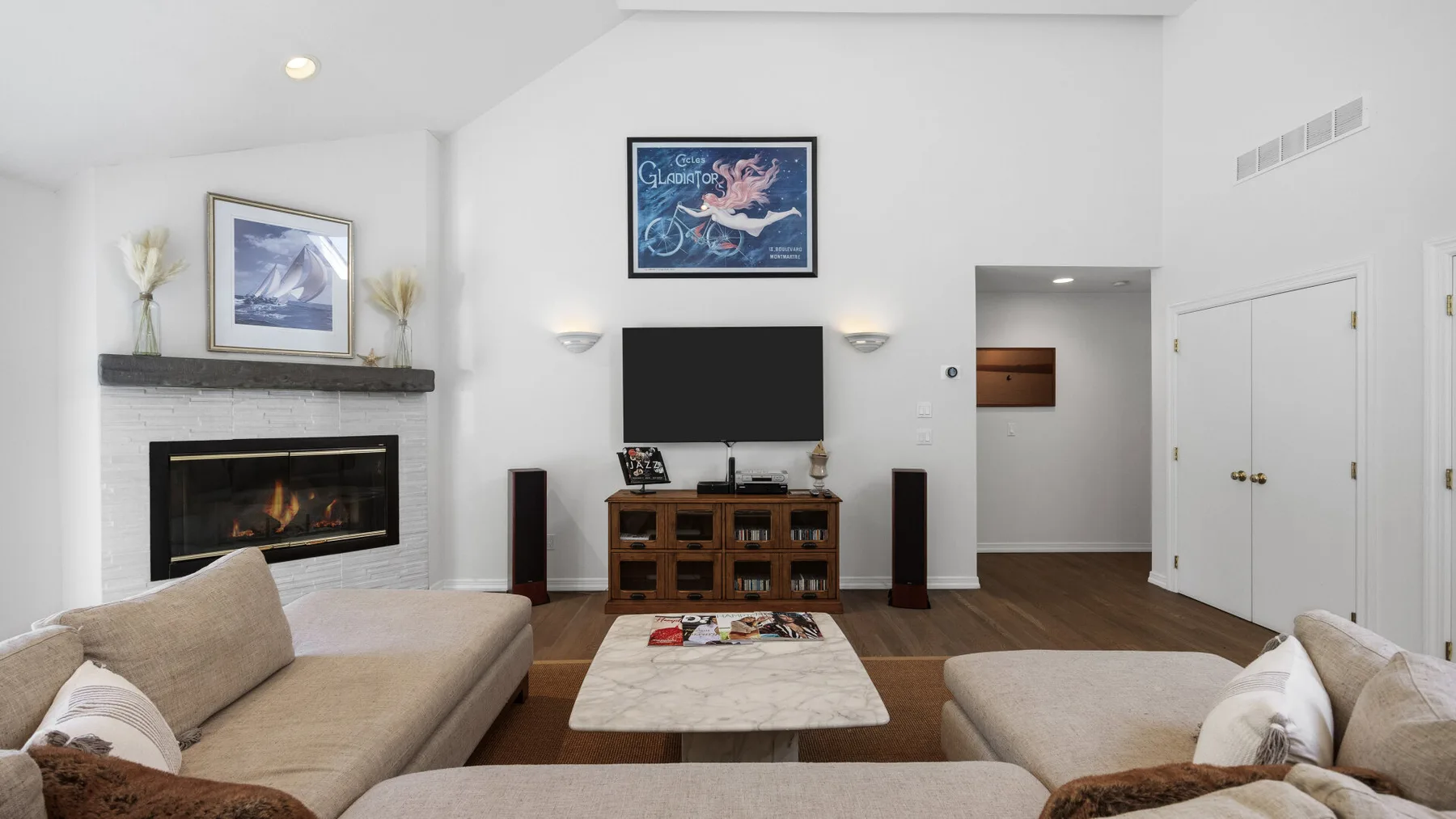 A living room with seating arranged around a coffee table and television.