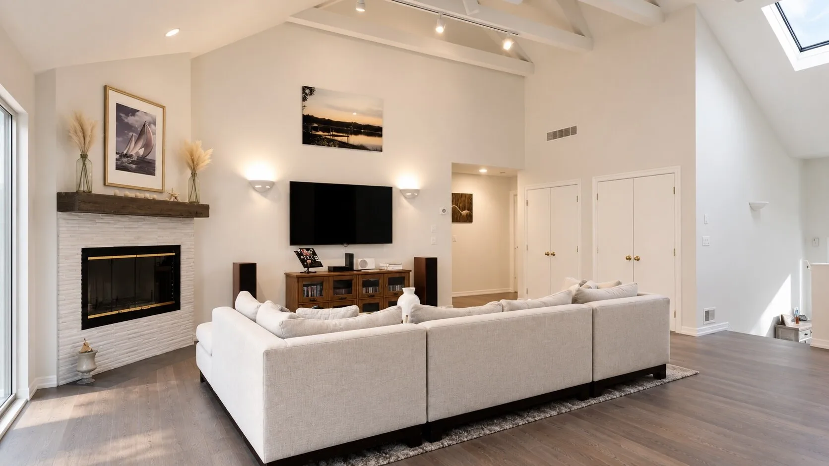 A bright living room with pale seating and a fireplace.