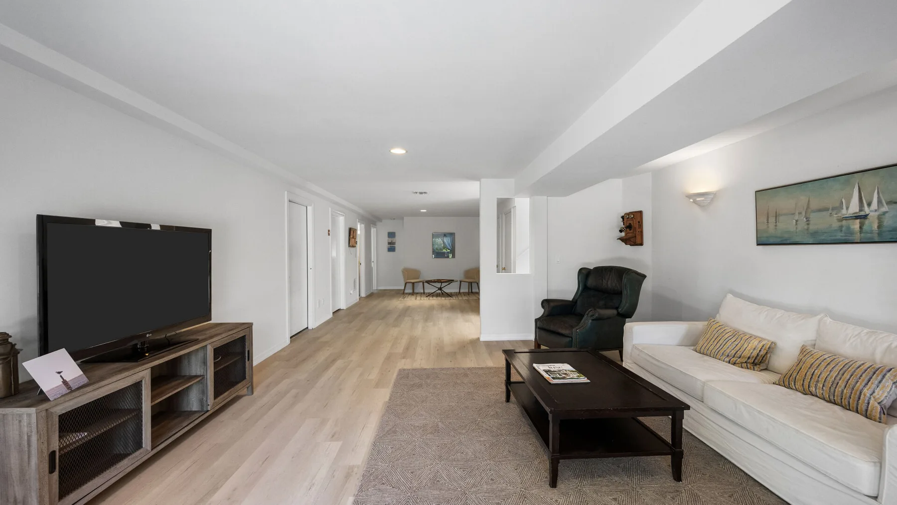 A bright living room with a television, seating, and a central coffee table.