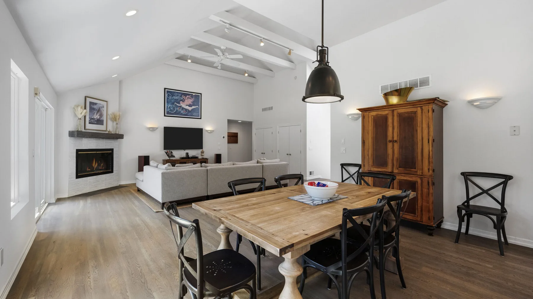 A bright open-plan living and dining room with a wooden dining table and seating.