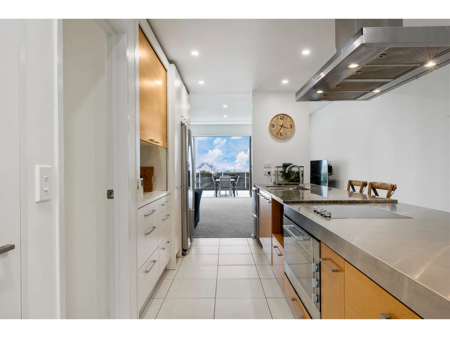 A modern kitchen with a long counter and a dining area visible beyond.