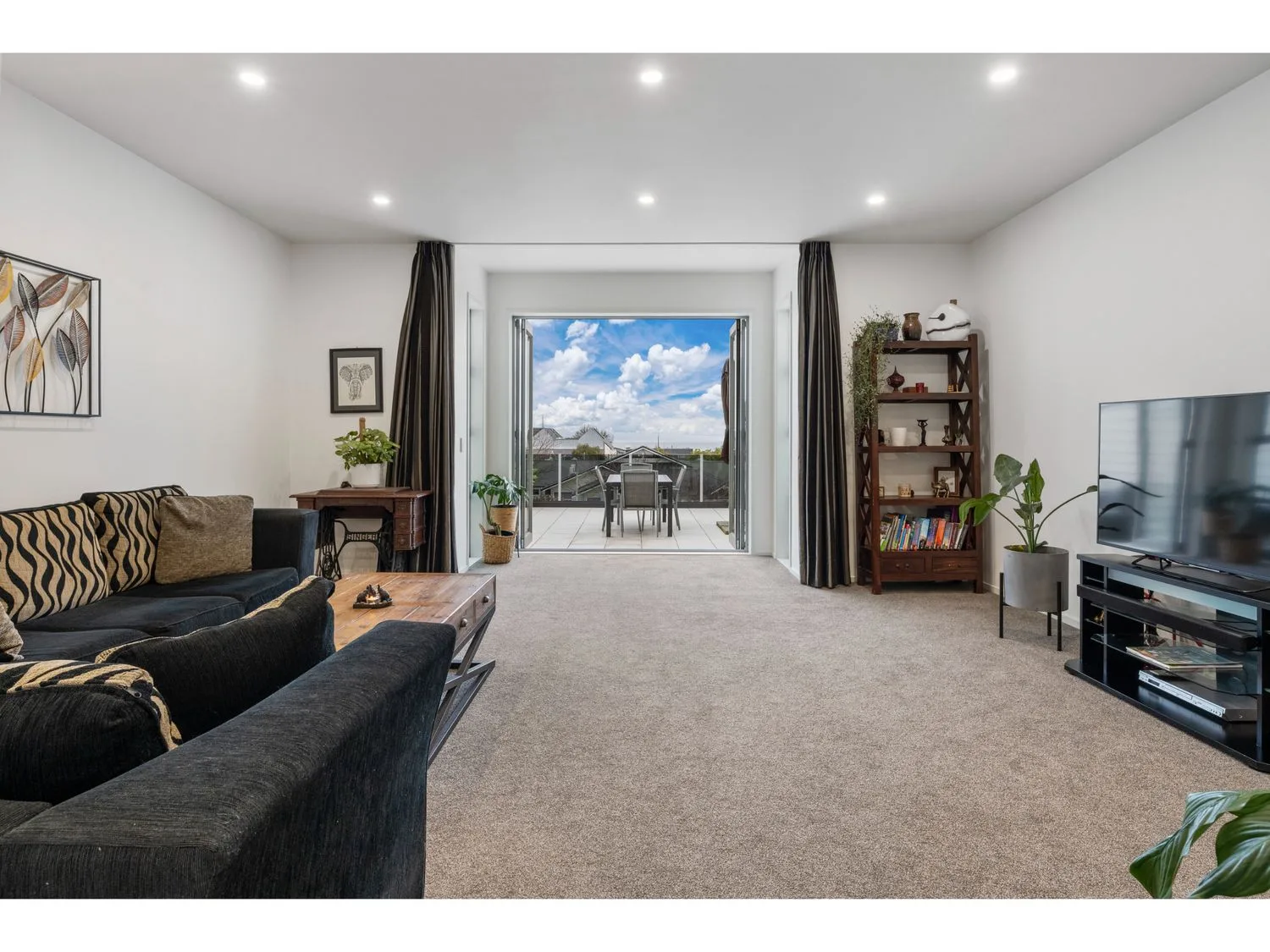A living room with seating, a coffee table, and sliding doors opening onto a balcony.