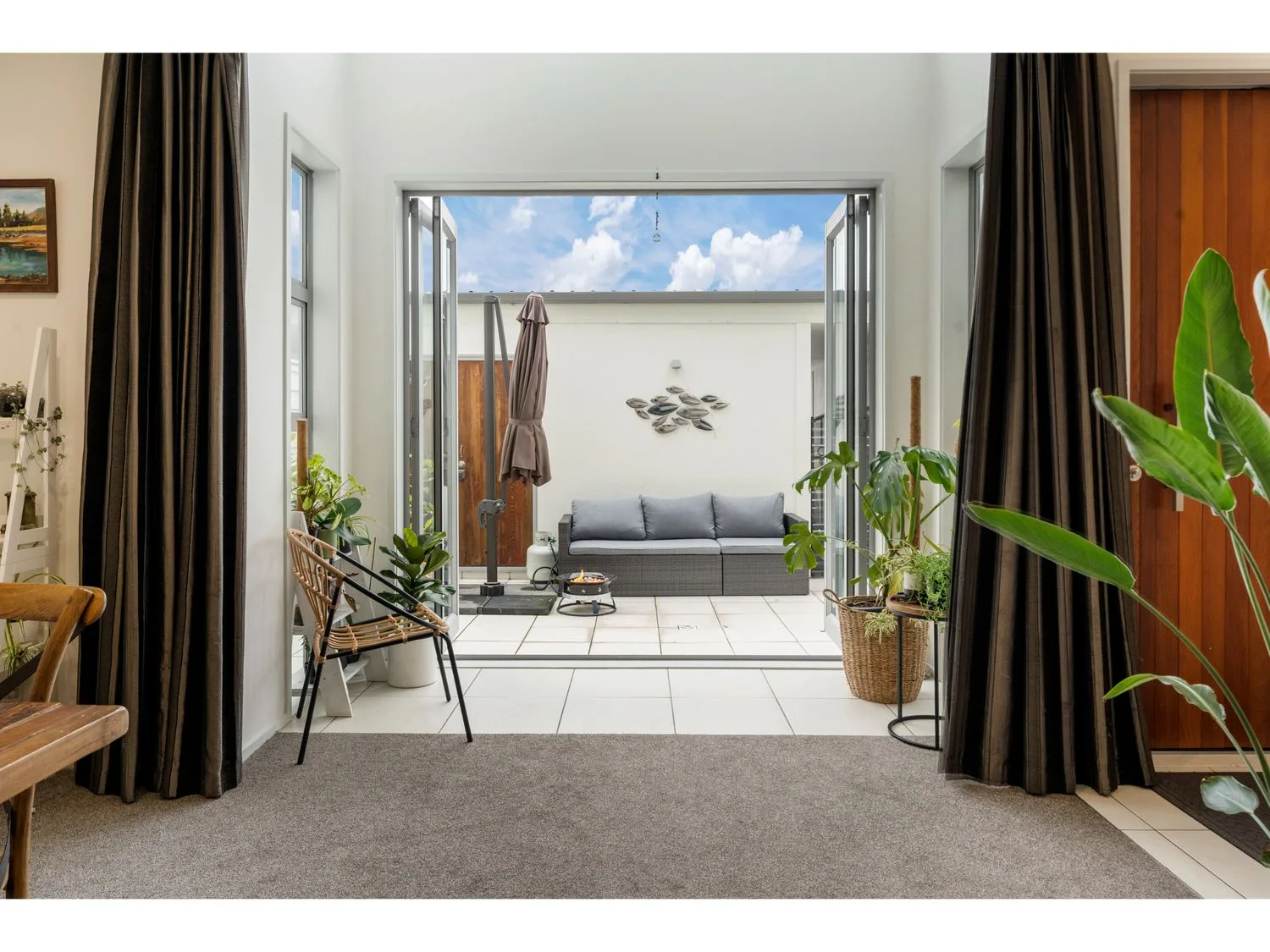 An indoor living area showing a view to an outdoor sitting space at Lakeview Luxury - Taupo Holiday Apartment, Taupo Central