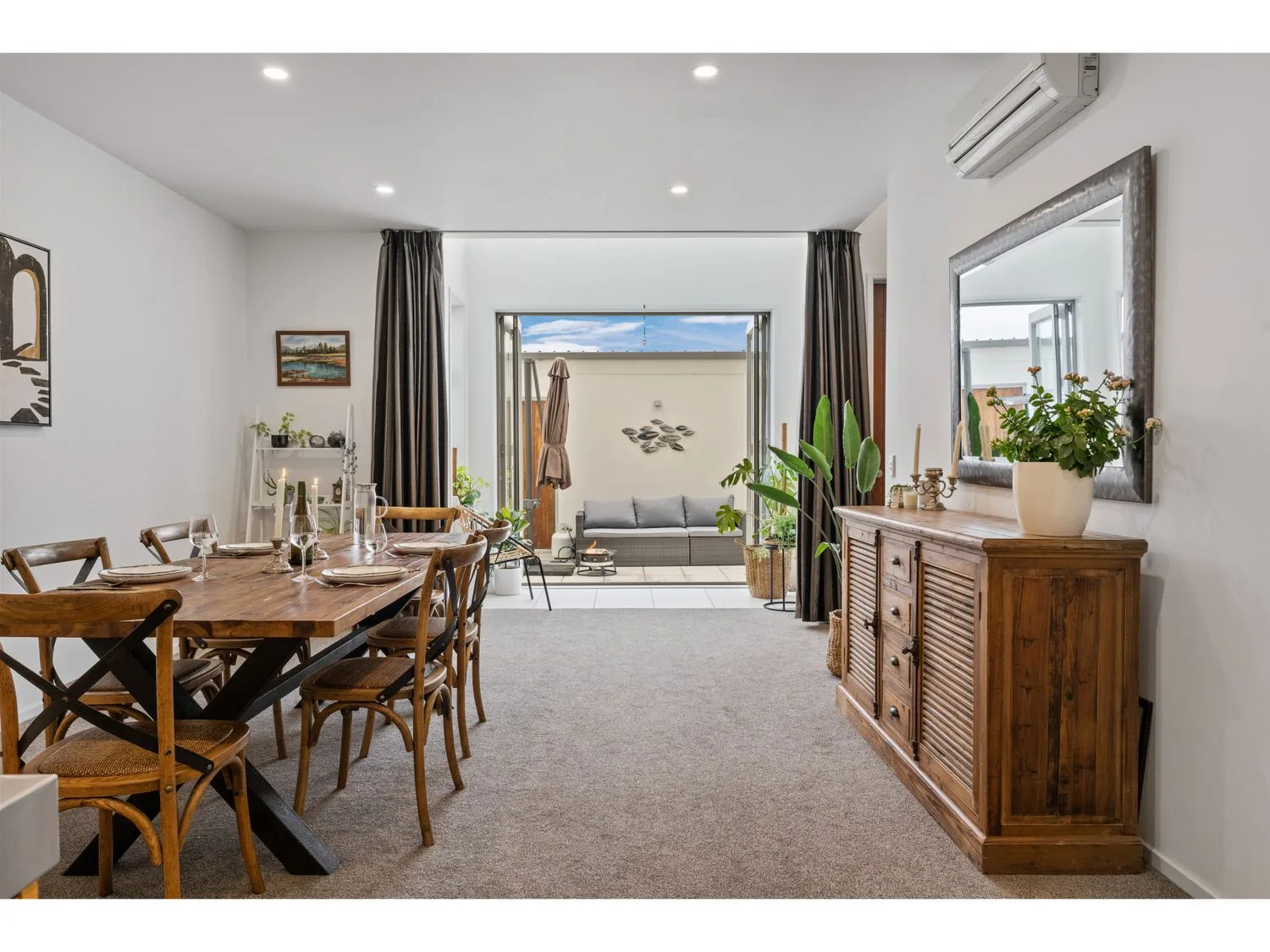 A dining and living area opens onto a balcony, with a dining table and seating.