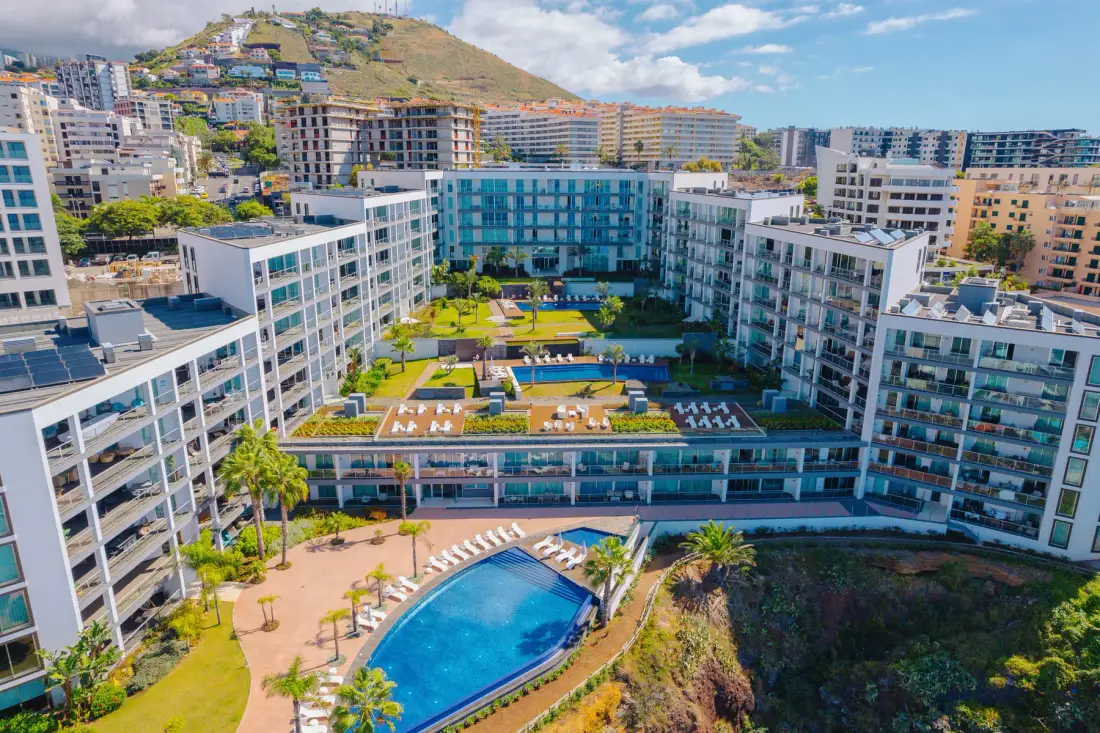 Aerial view of a large resort complex with a swimming pool and landscaped grounds.