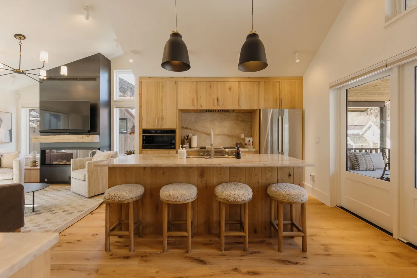 Una cocina abierta y luminosa con una isla de madera y taburetes.