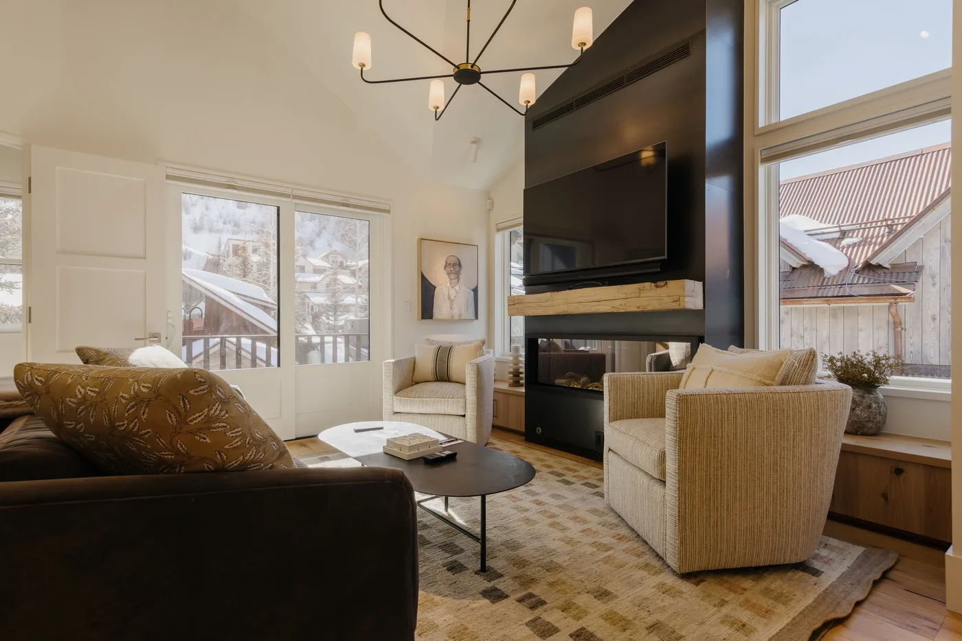 A bright living room with seating around a low coffee table and a fireplace.