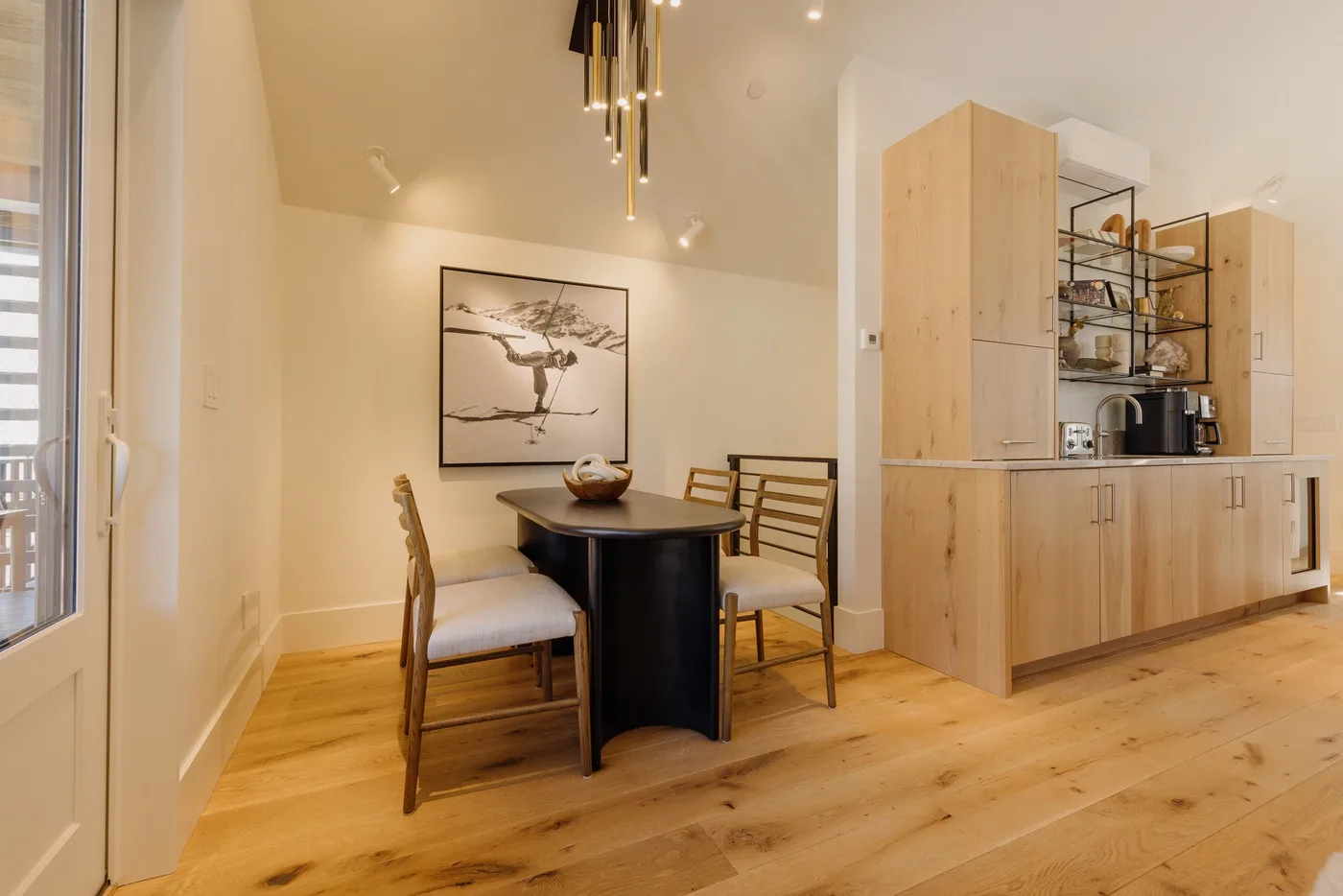 Comedor con mesa y sillas junto a una cocina de madera clara.
