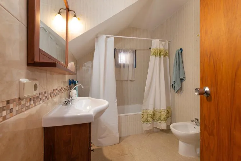 Un baño con lavabo, bañera y cortina de ducha.