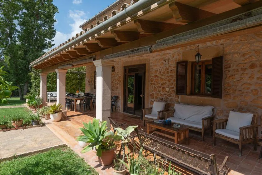 Un patio de piedra con asientos al aire libre y plantas en macetas.