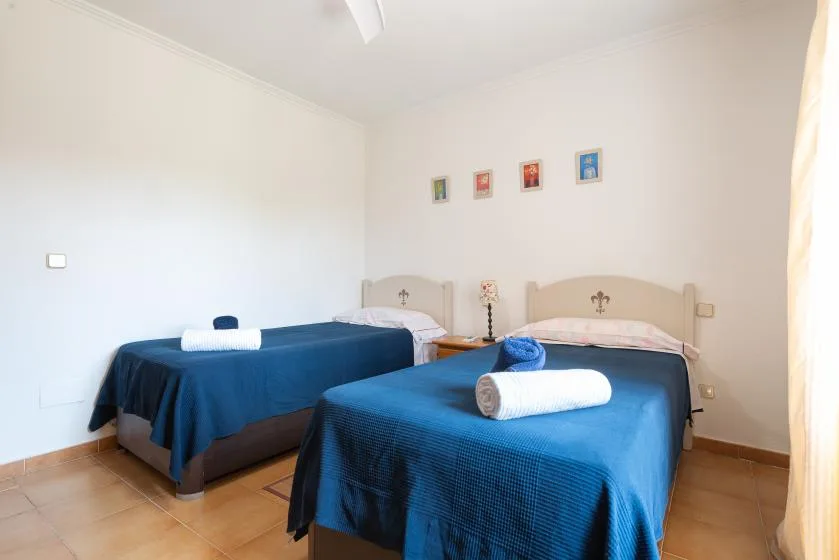Un dormitorio con dos camas cubiertas con colchas azules.