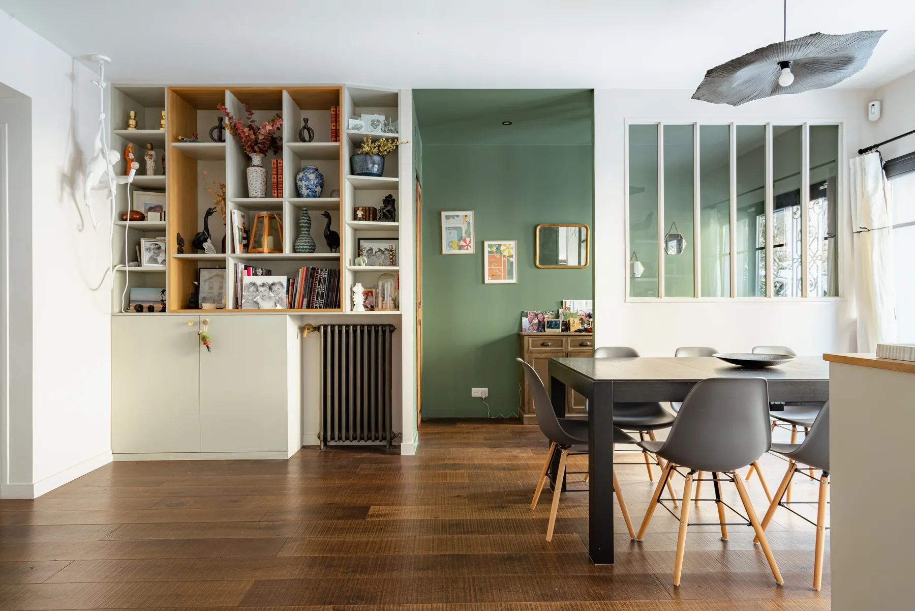 A dining area with a table and chairs beside built-in shelving.