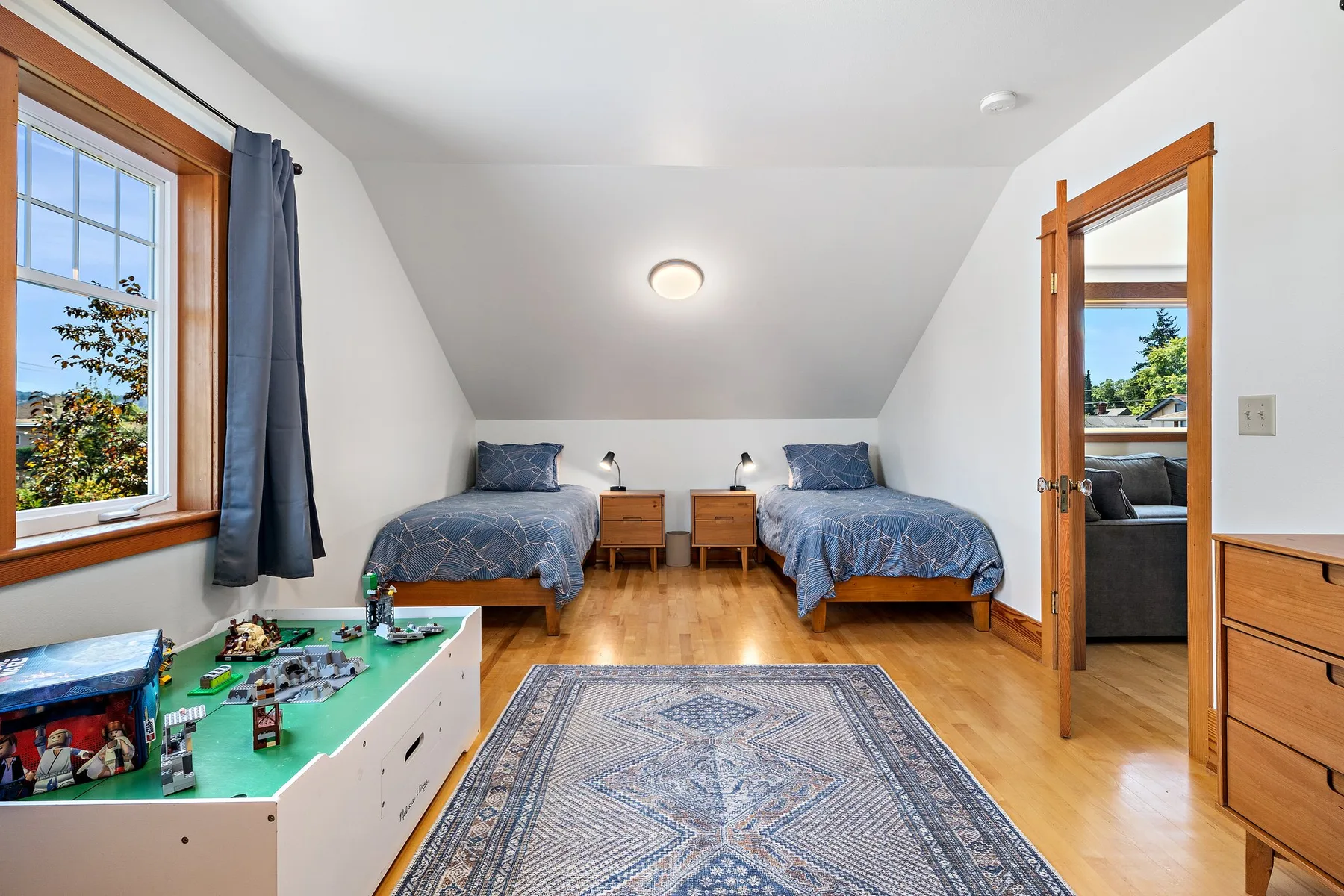 Un dormitorio con dos camas, una alfombra y una mesa de juegos.