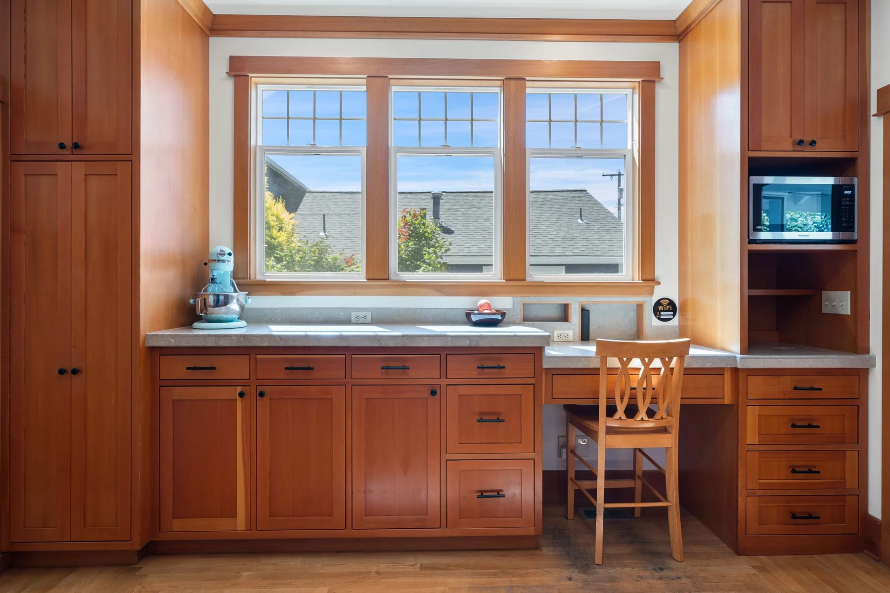 Una cocina con paneles de madera, una encimera larga y una ventana amplia.
